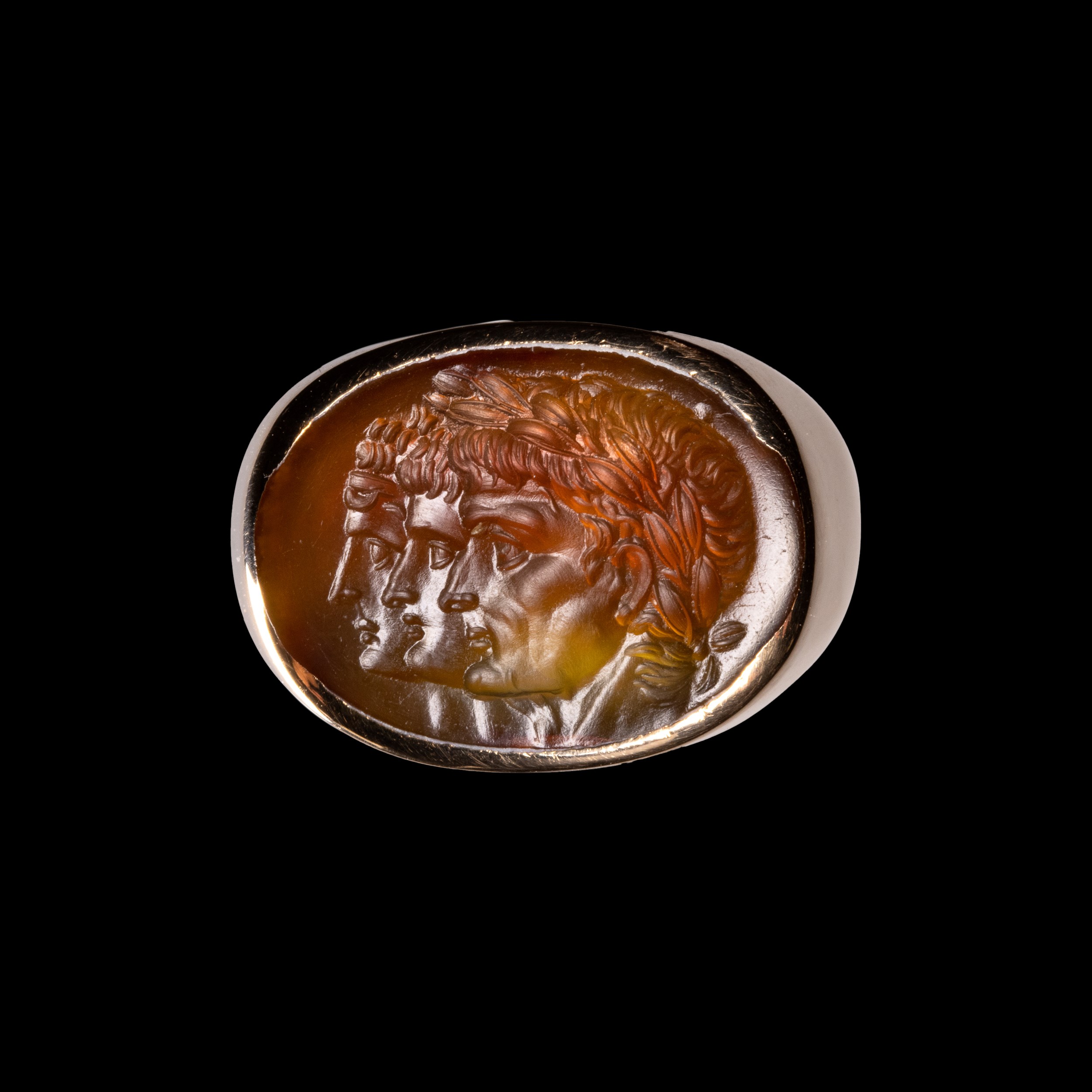 A gold ring with a Neoclassical agate intaglio. Three portraits. 